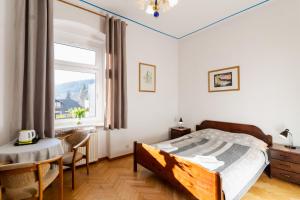 sypialnia z łóżkiem, stołem i oknem w obiekcie Hotel Europa w Polanicy Zdroju