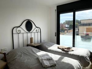 a bedroom with two beds and a large window at Escapada perfecta La Conca del Barberà in Santa Coloma de Queralt