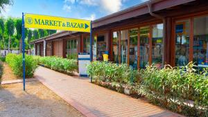 a store with a yellow sign in front of a building at Glamping at Sardinia in Alghero +37 photos