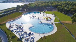 an overhead view of a large swimming pool with people in it at Glamping at Sardinia in Alghero