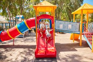 a man and a child on a slide at a playground at Glamping at Sardinia in Alghero