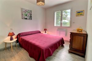 a bedroom with a bed with a red blanket at Maison chaleureuse Sud Ardèche in Pradons