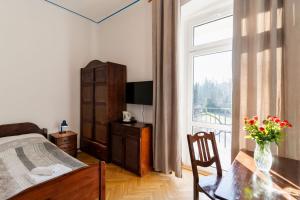 sypialnia z łóżkiem, stołem i oknem w obiekcie Hotel Europa w Polanicy Zdroju