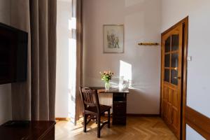 Pokój ze stołem, krzesłem i wazą kwiatów w obiekcie Hotel Europa w Polanicy Zdroju