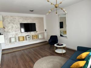 a living room with a couch and a tv on a wall at Central in inima orasului in Ploieşti