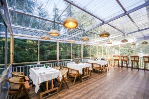a conservatory with tables and chairs in a restaurant at The Bunksters Mcleodganj, Dharmkot in McLeod Ganj