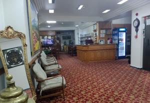 a waiting room with chairs and a clock in a store at Hotel Cesmeli in Bursa