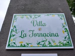 a sign on the side of a building with flowers at Villa La Fornacina Apartments in Barberino di Mugello