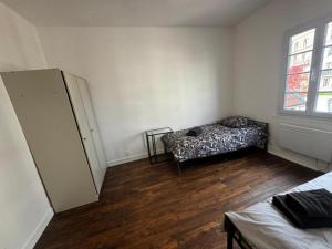 a room with a bed and a refrigerator in it at Oliasi Poissy in Poissy