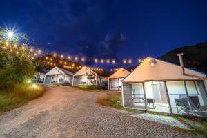a row of houses lit up at night with lights at Pocheon KidsGlampingGEO in Pocheon