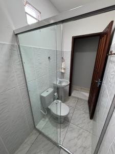 a bathroom with a toilet and a glass shower at Hotel Calleb in Presidente Figueiredo +27 photos