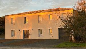 a large white house with a garage at Le Bonheur de l'Instant in Saint-Médard-dʼAunis