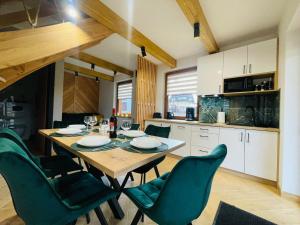 a kitchen and dining room with a wooden table and chairs at Gąsienicowy Widok in Poronin