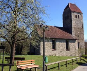 eine alte Kirche mit Straßenlicht und Bank in der Unterkunft Gästezimmer Kippenhausen in Immenstaad am Bodensee