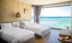 two beds in a hotel room with a view of the ocean at Serō Boutique Hotel in Cù Lao Thu +45 photos