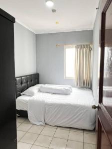 a bedroom with two beds and a window at Cozy Central Jakarta Apartment in Jakarta