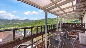 a balcony with a table and chairs and mountains at Gapyeong Bonita Pension in Gapyeong +2 photos