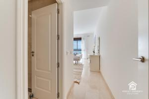 a hallway with a door leading to a living room at Golfer's paradise - 2BR with garage and pool in San Roque +31 photos