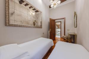 a bedroom with two beds and a chandelier at Cà dell'arte Suite in Venice