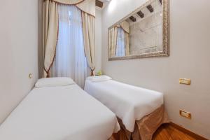 two beds in a small room with a window at Cà dell'arte Suite in Venice +114 photos