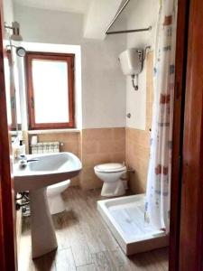 a bathroom with a toilet and a sink and a tub at La Stella Alpina in Tagliacozzo