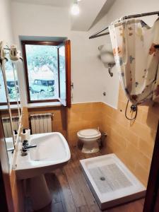 a bathroom with a sink and a toilet and a window at La Stella Alpina in Tagliacozzo