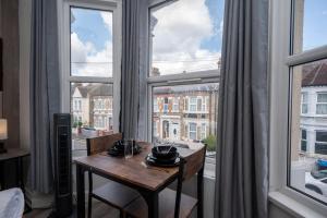 a table in a room with a large window at Gilded Nooks in Croydon