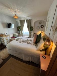 a bedroom with a large white bed and a couch at The Sun in Wells