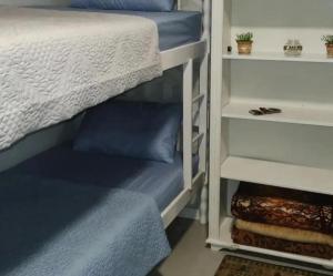 a bedroom with a bunk bed with blue pillows at Quarto Familiar Sil Cardoso in Blumenau
