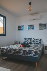 a bedroom with a bed with a patterned comforter at OISEAUX DU PARADIS - Bungalow 2 voyageurs in Saint-Leu