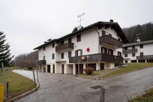 a large white building with balconies on a street at Appartamento Eva in Folgaria