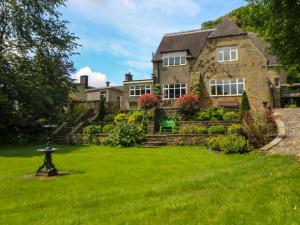 a house with a green lawn in front of it at The Old Coach House in Buxton