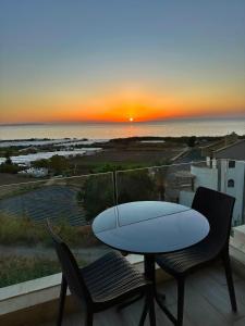 a surfboard on a table on a balcony with a sunset at Haya Hotel And Spa in Tabarja