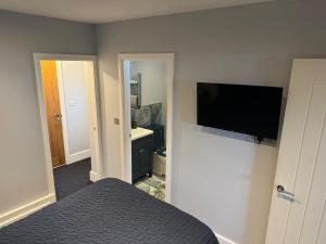 ein Schlafzimmer mit einem Bett und einem Flachbildfernseher in der Unterkunft Cozy Apartment in Stoke-on-Trent One double bed in Stoke on Trent