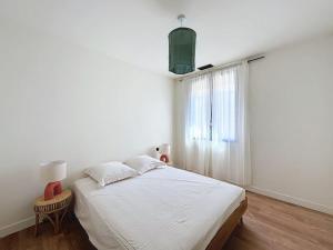 a white bedroom with a bed and a window at Villa de l'Ange en Provence in Eyragues +19 photos