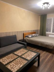 a room with two beds and a couch and a table at Cat Garden Business Apartments Riga in Rīga