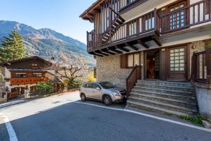 une petite voiture garée devant une maison dans l'établissement Graceful Apartment In Courmayeur - Happy Rentals, à Courmayeur
