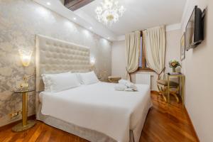 a bedroom with a large white bed in a room at Cà dell'arte Suite in Venice