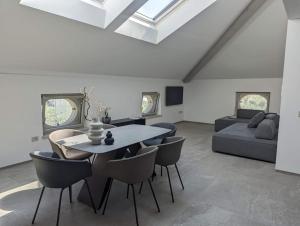 een woonkamer met een tafel, stoelen en een bank bij Villa Sembenini Loft in Riva del Garda