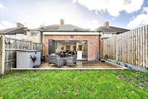 a backyard with a wooden deck and a fence at House with Garden Next Wembley Stadium Free Parking in London