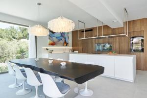 a kitchen with a black table and white chairs at Casa Cristiano in Sant Josep de Sa Talaia