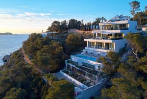 a large building on a hill next to the water at Casa Cristiano in Sant Josep de Sa Talaia