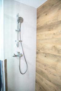 a shower with a shower head on a wall at Zidanica sredi dolenjskih gričev - V gaj in Trebnje