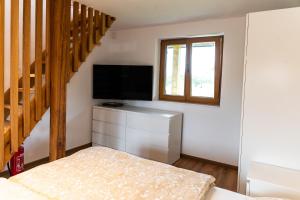 a living room with a television and a staircase at Zidanica sredi dolenjskih gričev - V gaj in Trebnje