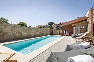 a swimming pool next to a stone wall at Beco do Paço by Porto Dream Stays in Porto