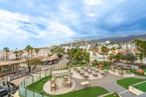 a park with tables and chairs in a city at Luxury Studio 1 ocean view wifi free in Adeje
