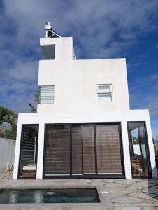 a white building with a large window at Cosy house with pool in Amitié