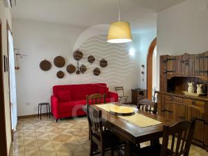 a living room with a red couch and a table at Casa Estela By Cala Salento in Porto Cesareo