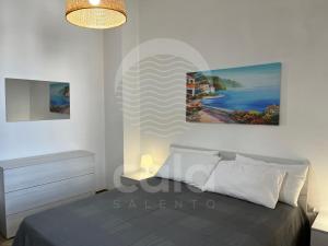 a bedroom with a bed and a painting on the wall at Casa Estela By Cala Salento in Porto Cesareo