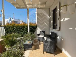 a patio with chairs and a table on a balcony at Casa Estela By Cala Salento in Porto Cesareo